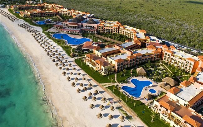Aerial view of a large beachfront resort with pools on the Caribbean coast near Cancún