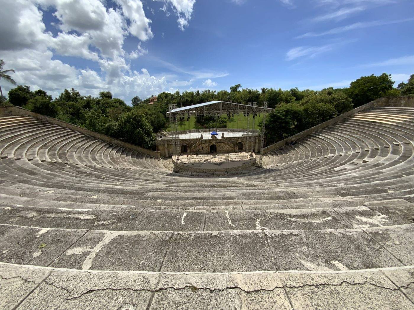 The tiered stone seats of the open-air amphitheater at Altos de Chavón surrounded by green hills