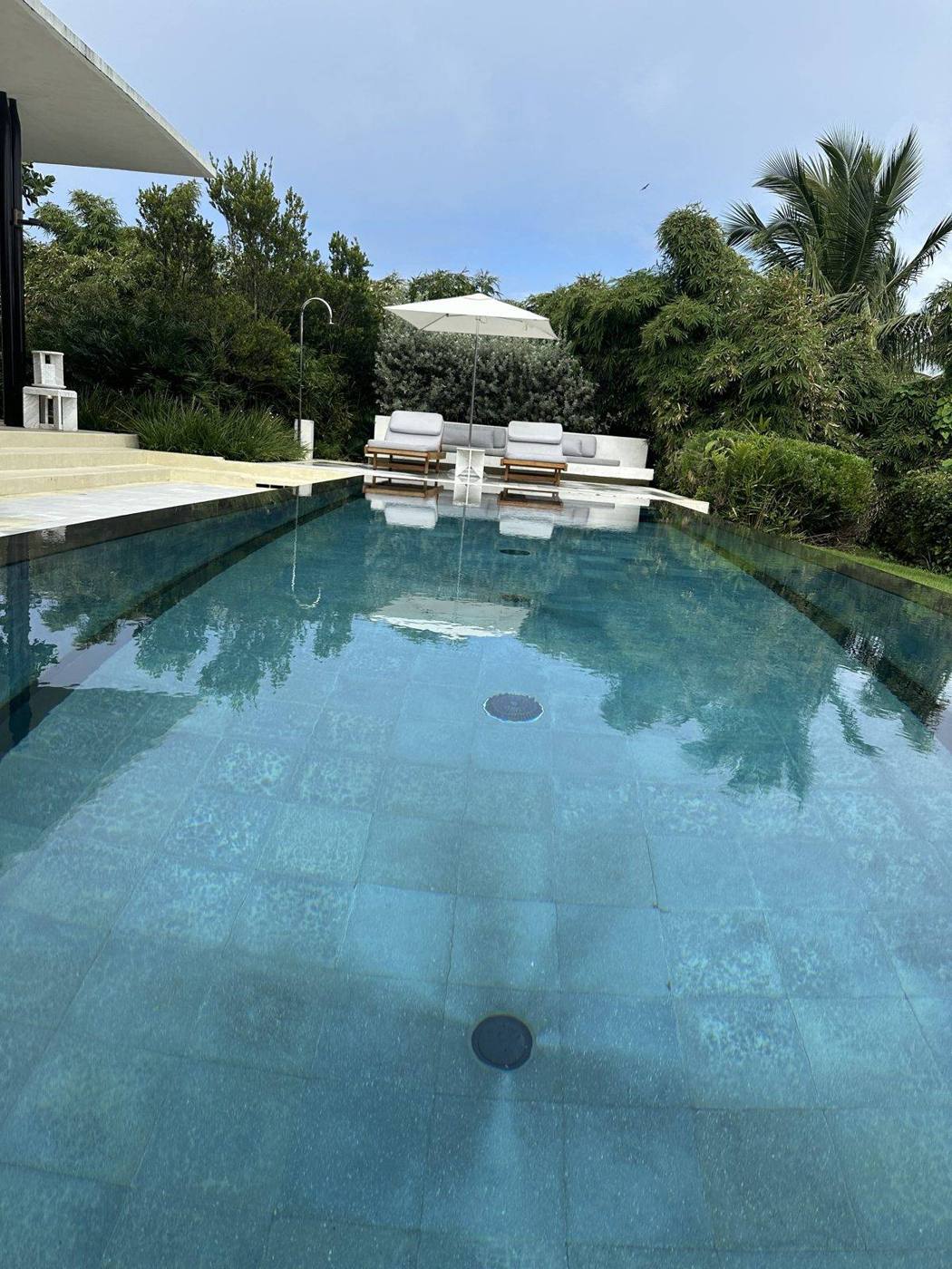 A private villa infinity pool surrounded by tropical gardens