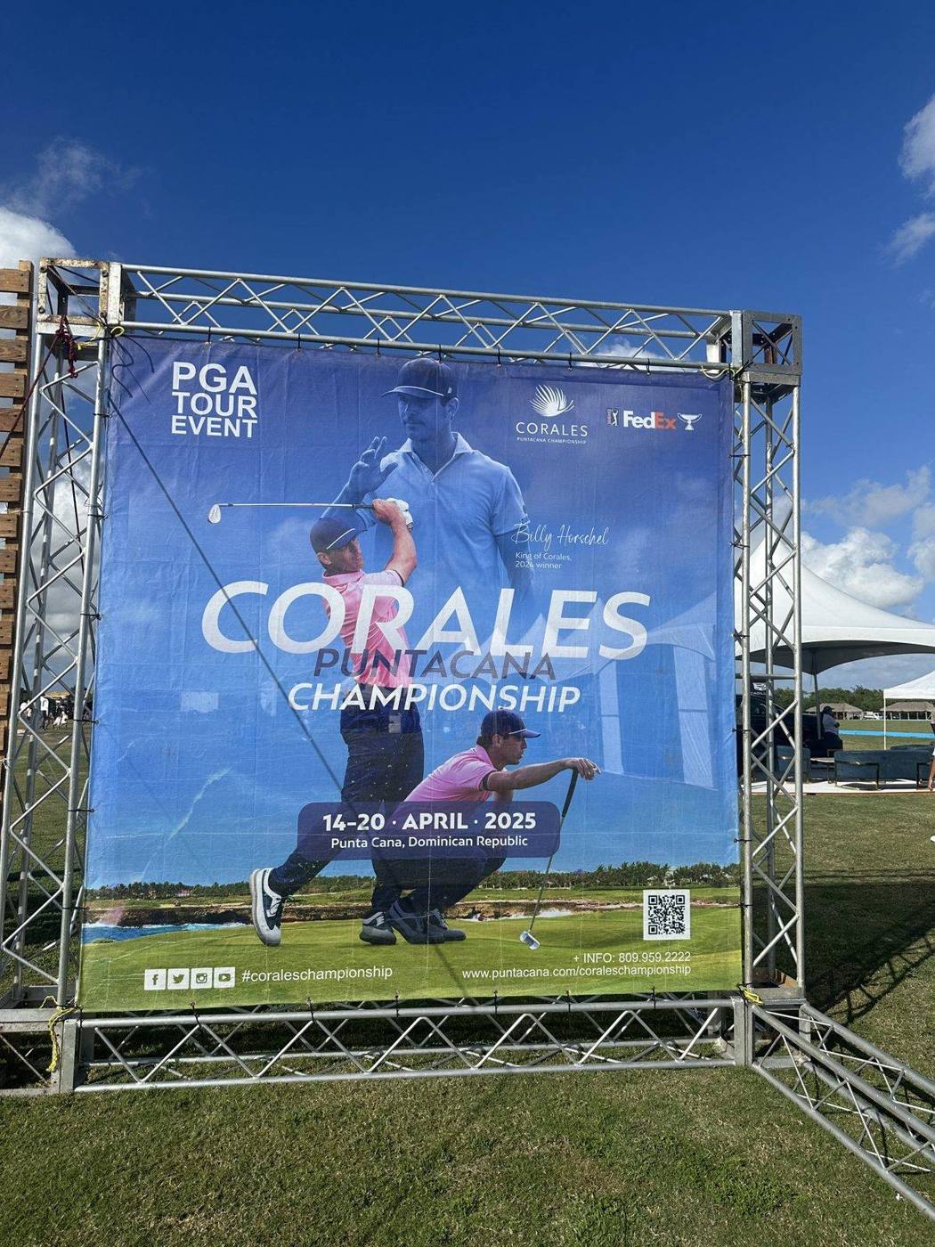 A large banner for the PGA Tour Corales Puntacana Championship, April 14 to 20, 2025, on a metal frame