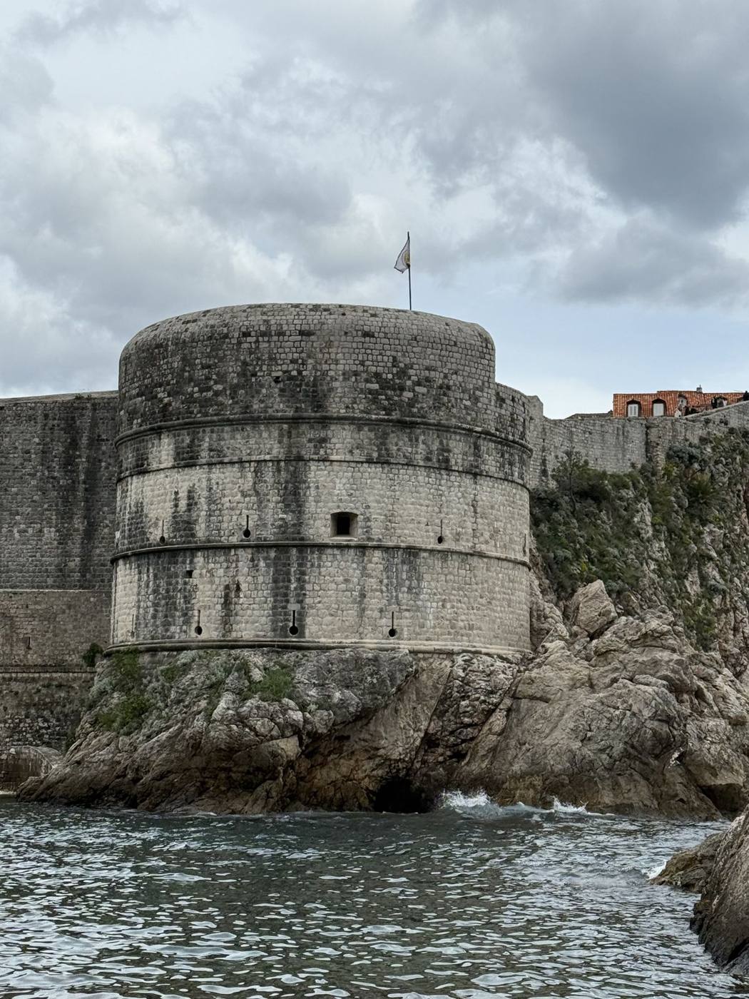 The round stone Bokar Fortress rising from the rocks at the edge of the sea