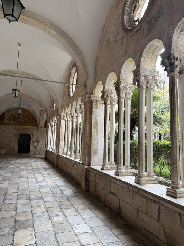 Arched stone columns around the cloister garden of the Franciscan Monastery in Dubrovnik
