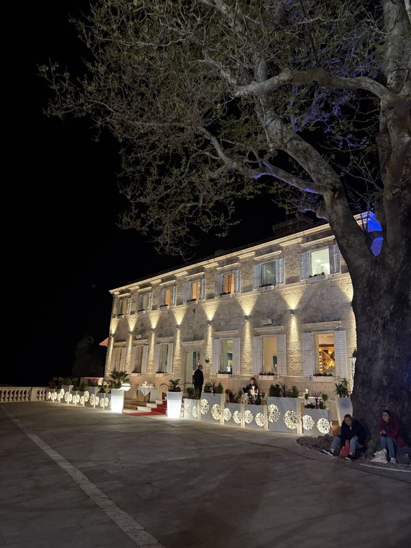 The lit stone facade and terrace of Nautika restaurant at night beside Dubrovnik’s walls