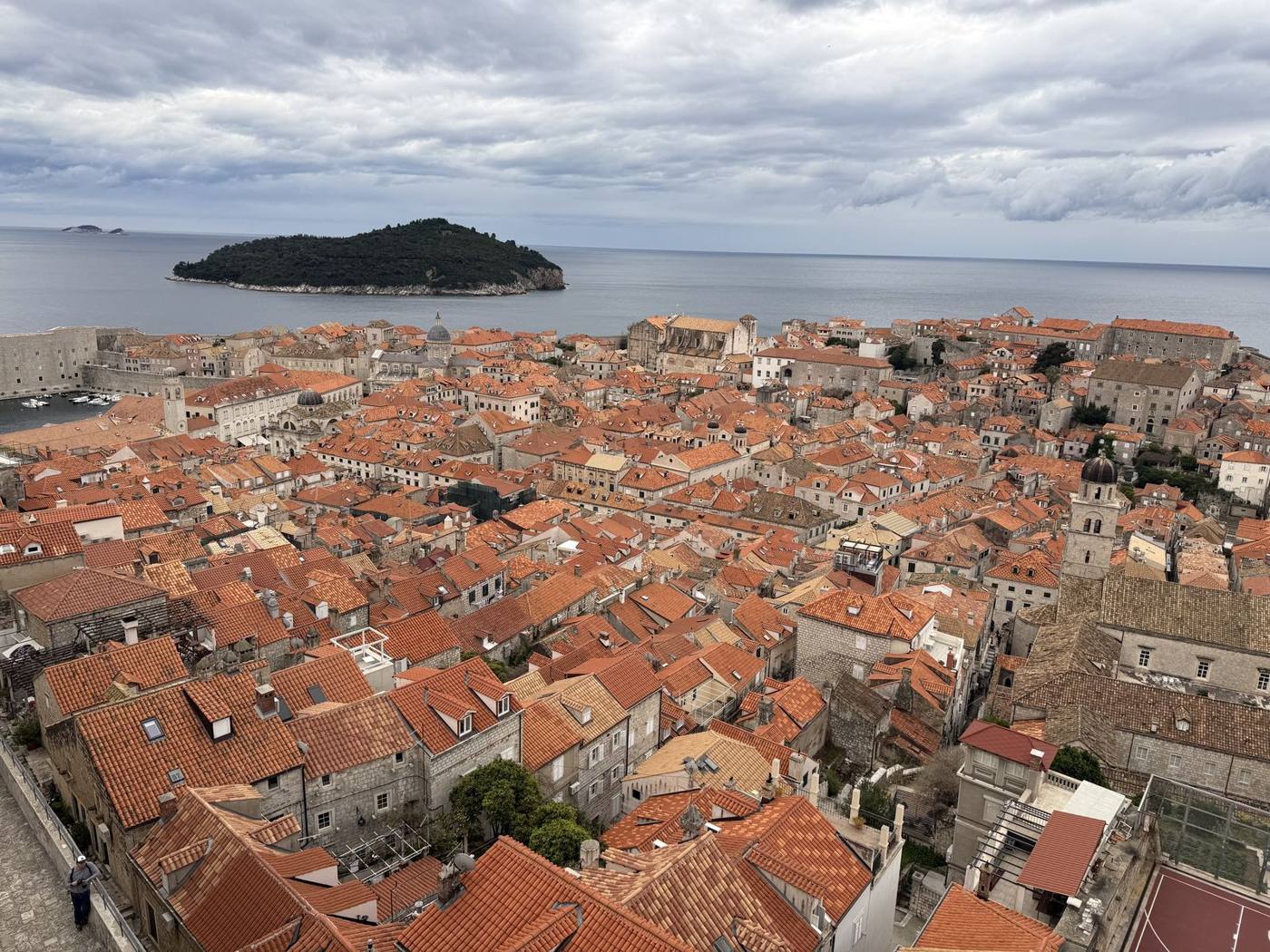 A sea of terracotta rooftops inside Dubrovnik’s Old Town, with Lokrum Island in the Adriatic beyond
