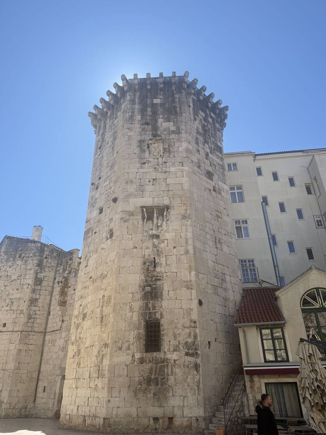 The square stone tower of Kamerlengo Fortress against a deep blue sky in Trogir