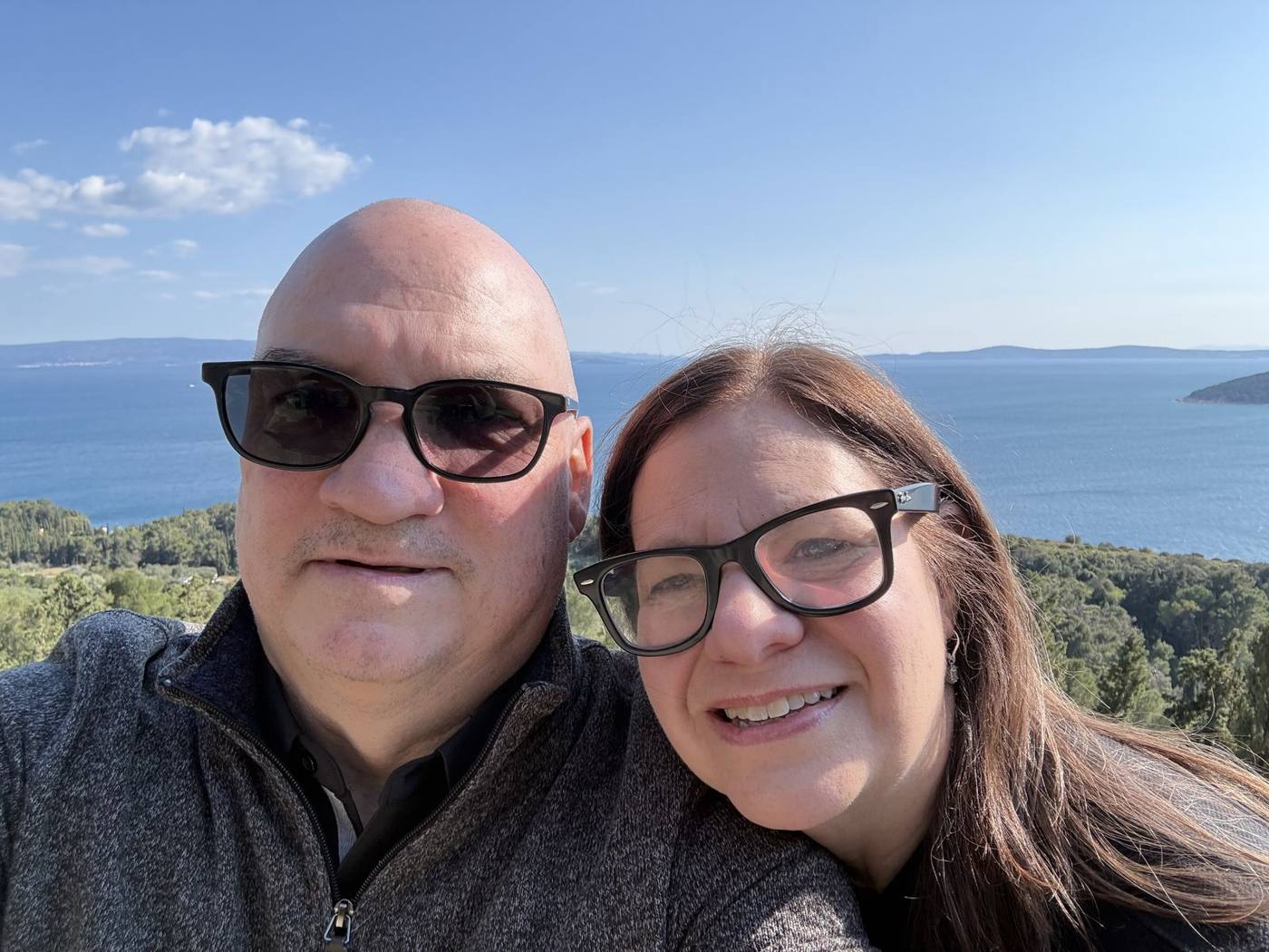 Troy and Mikki in sunglasses smiling in a selfie on Marjan Hill, with the blue Adriatic and islands behind them