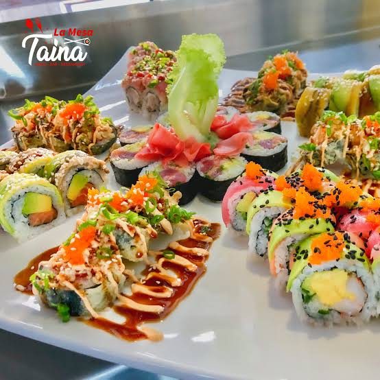 A platter of colorful sushi rolls topped with sauces, fish roe and sesame