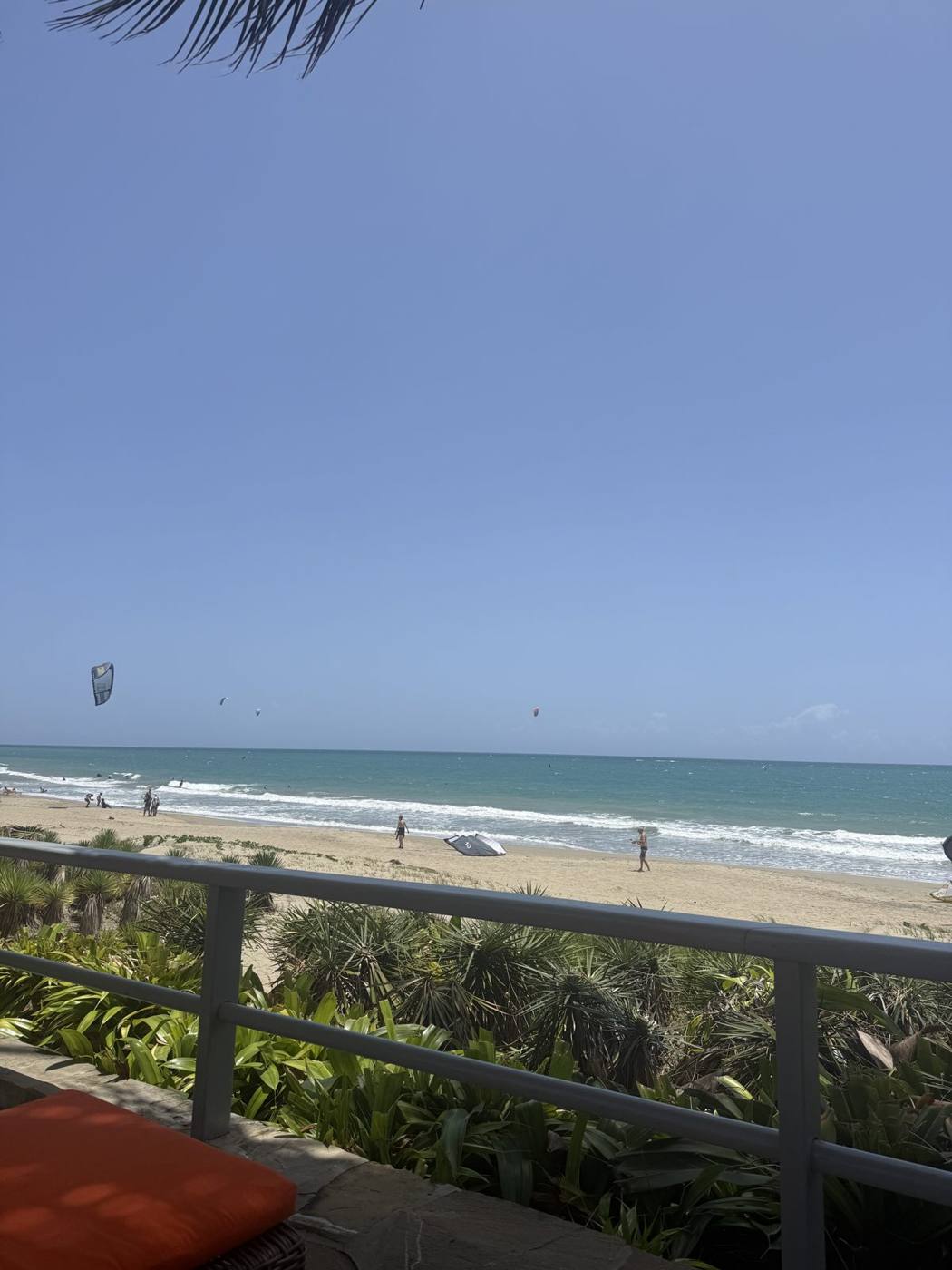 The view over the villa railing to Kite Beach with kites in the sky
