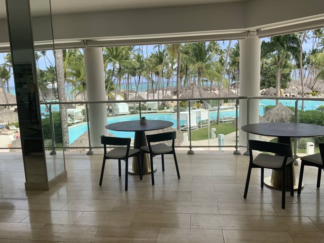 Restaurant tables with a view of the pool and palms