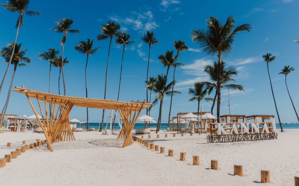 White-sand beach with palm trees and a wooden beach lounge at Paradisus Palma Real