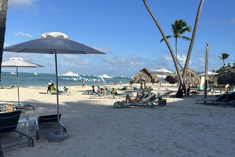 A white-sand beach in Punta Cana with umbrellas, loungers and tall palm trees